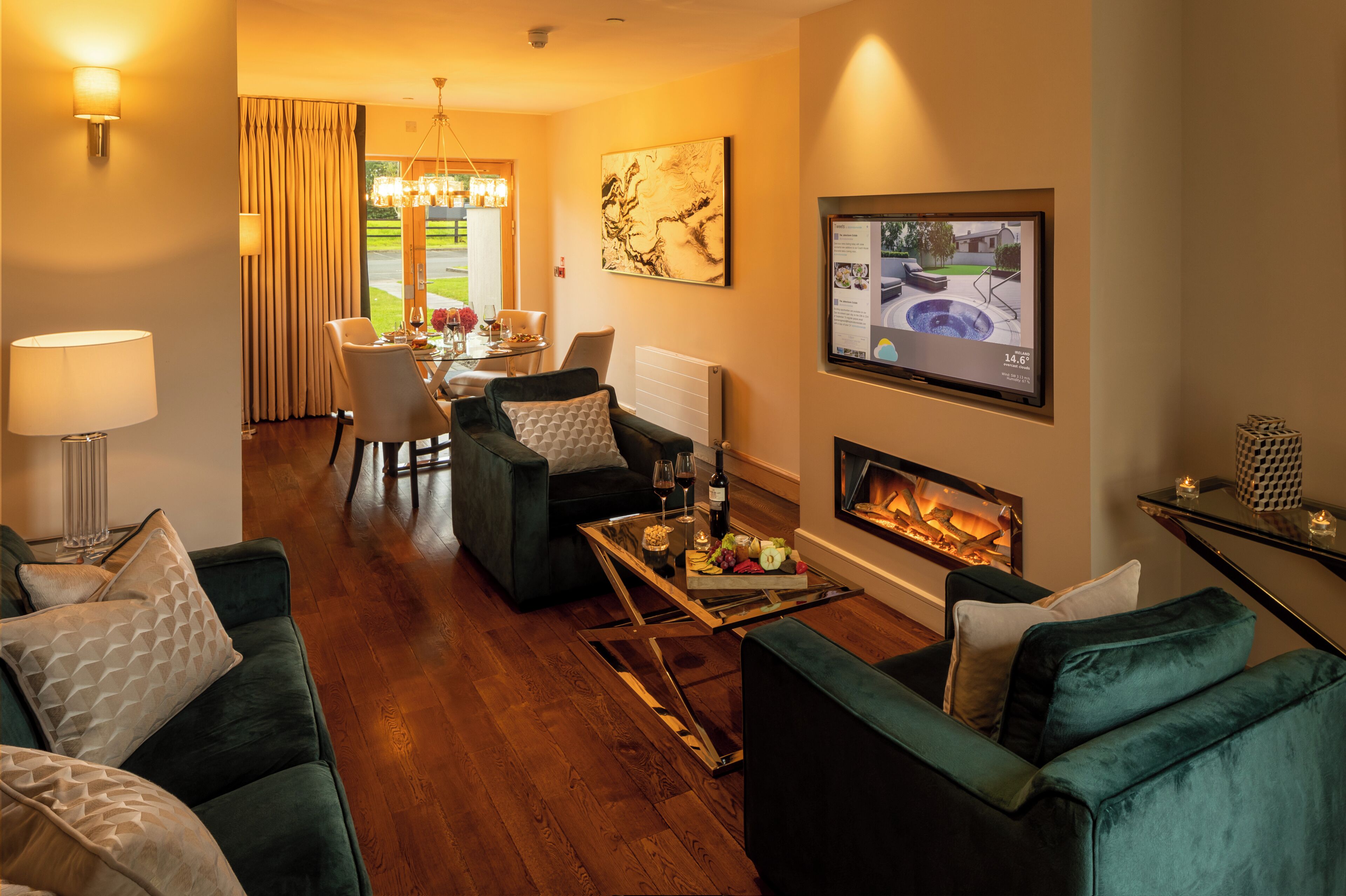 Una sala de estar con chimenea, un comedor con mesa y sillas, y vistas al exterior.