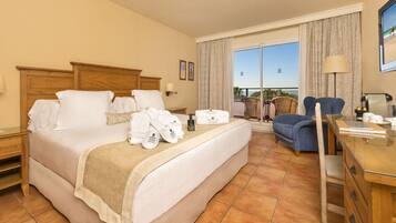 Habitación de hotel con una cama grande, un escritorio, una silla y vistas al exterior.