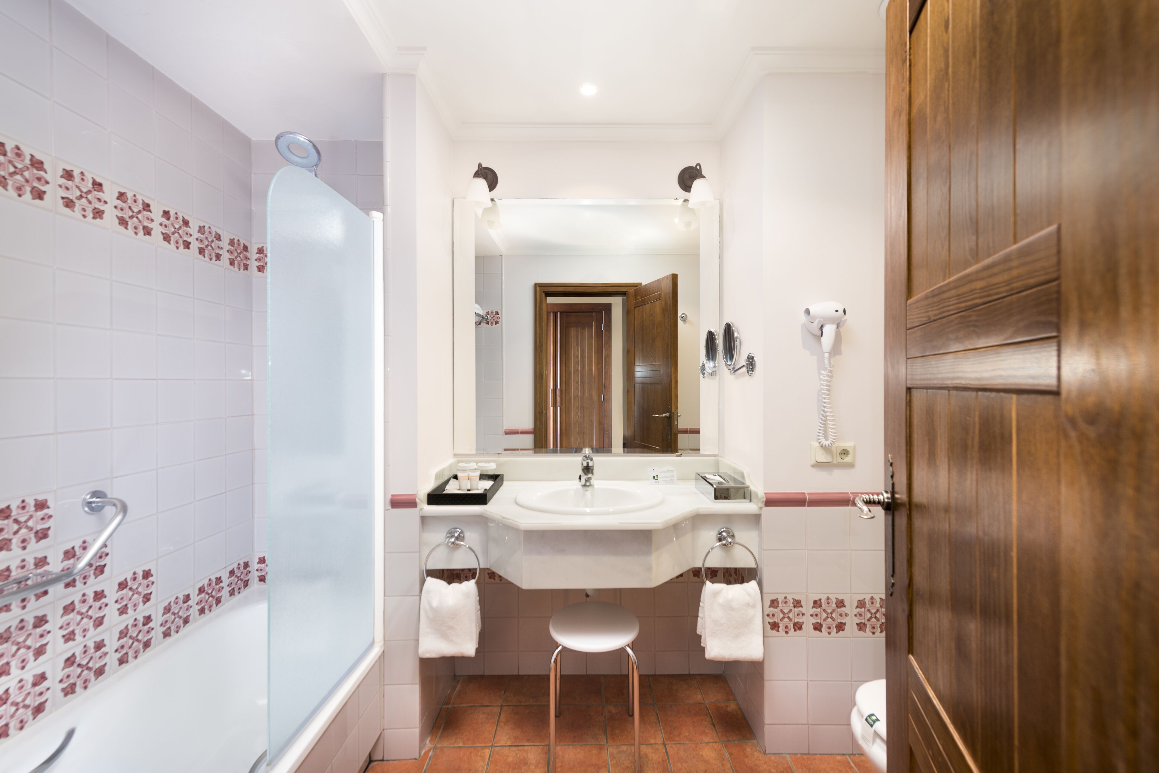 A bathroom with a shower, sink, and toilet.