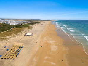 På stranden, vit sandstrand, solstolar och parasoller
