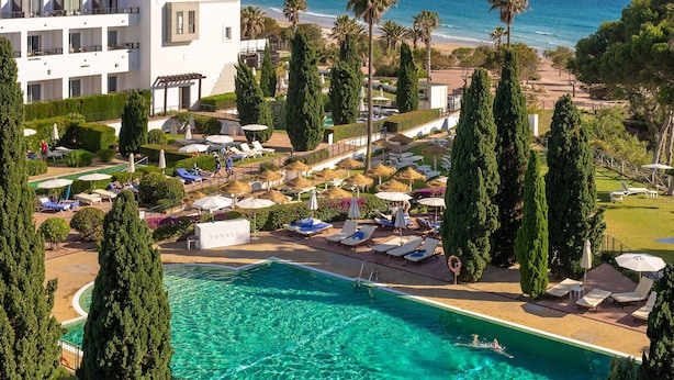 A resort with a swimming pool, sun loungers, and a view of the ocean. - Hotel Fuerte Conil-Resort (Conil de la Frontera)
