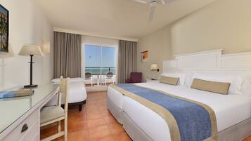 Ein Hotelzimmer mit Bett, Schreibtisch, Stuhl und Meerblick durch das Fenster.