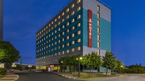 Um hotel de vários andares com design moderno, exibindo uma placa grande com a palavra 'HOTEL' na lateral.