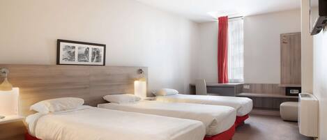 A hotel room with two beds, a desk, a chair, a TV, and a window with curtains.