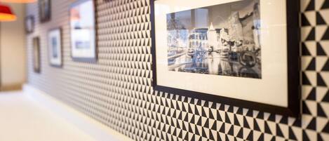 A hallway with patterned walls and framed photographs.