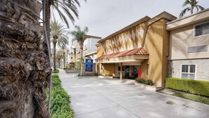 A hotel entrance with a sign for 'Armani's Best Value Inn & Suites'. - Americas Best Value Inn & Suites Anaheim Convention Center (Anaheim)