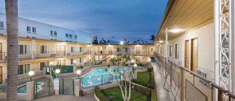 Una piscina al aire libre, sombrillas, sillones reclinables de piscina