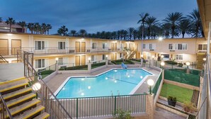 A multi-story hotel with a central swimming pool, outdoor stairs, and balconies. - Americas Best Value Inn & Suites Anaheim Convention Center (Anaheim)