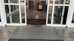 A hotel entrance with a doormat reading "Homestead Apart-Hotel" and a sign indicating "No Smoking". - Homestead Apart-Hotel (Pleasantville)