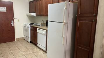 Una cocina con armarios de madera, un refrigerador blanco, una estufa y un lavavajillas.