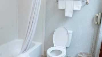 Een badkamer met een badkuip, toilet en douchegordijn.