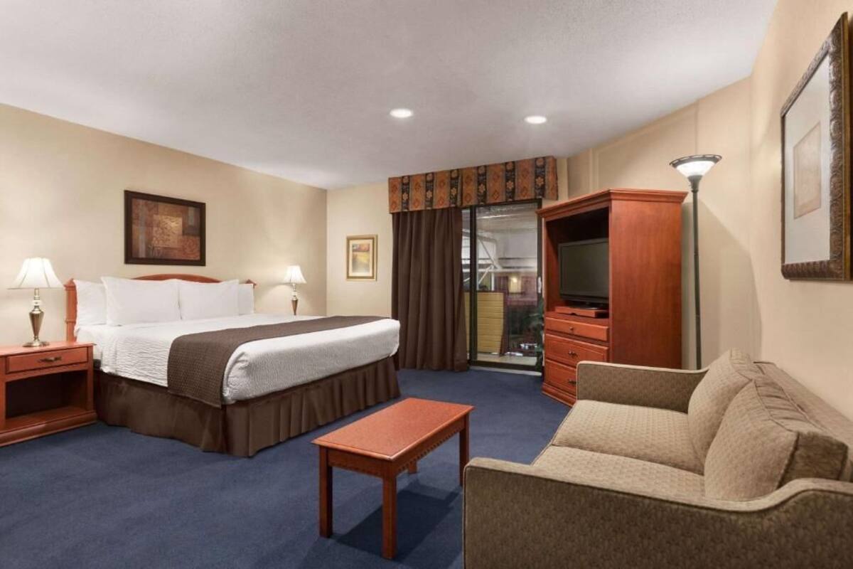 Une chambre d’hôtel équipée d’un lit, d’un bureau, d’une chaise, d’une télévision et d’une armoire.