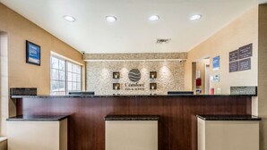 A reception area with a marble wall, a sign reading "Comfort Inn & Suites," and a window on the left. - Comfort Inn & Suites Dayton North (Dayton)