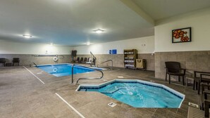 A large indoor swimming pool with multiple lanes, a changing room, and a seating area with chairs. - Comfort Inn & Suites Dayton North (Dayton)