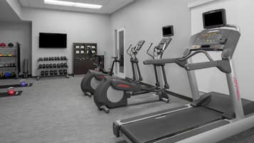 A gym with treadmills, elliptical machines, and weightlifting equipment.