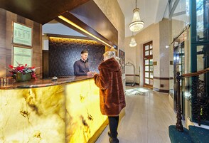 Et hotelværelse med en marmor disk, en indrammet velkomstskilt og en receptionsdisk.