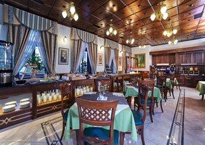 Un ristorante con pannelli in legno, lampadari e un'area buffet con diversi piatti.