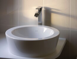 Ein modernes Badezimmer mit Toilette und einem wandmontierten Waschbecken.