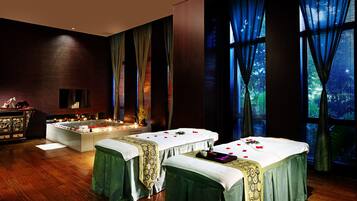 Relax in a serene spa room with two massage tables, a seating area, and large windows.