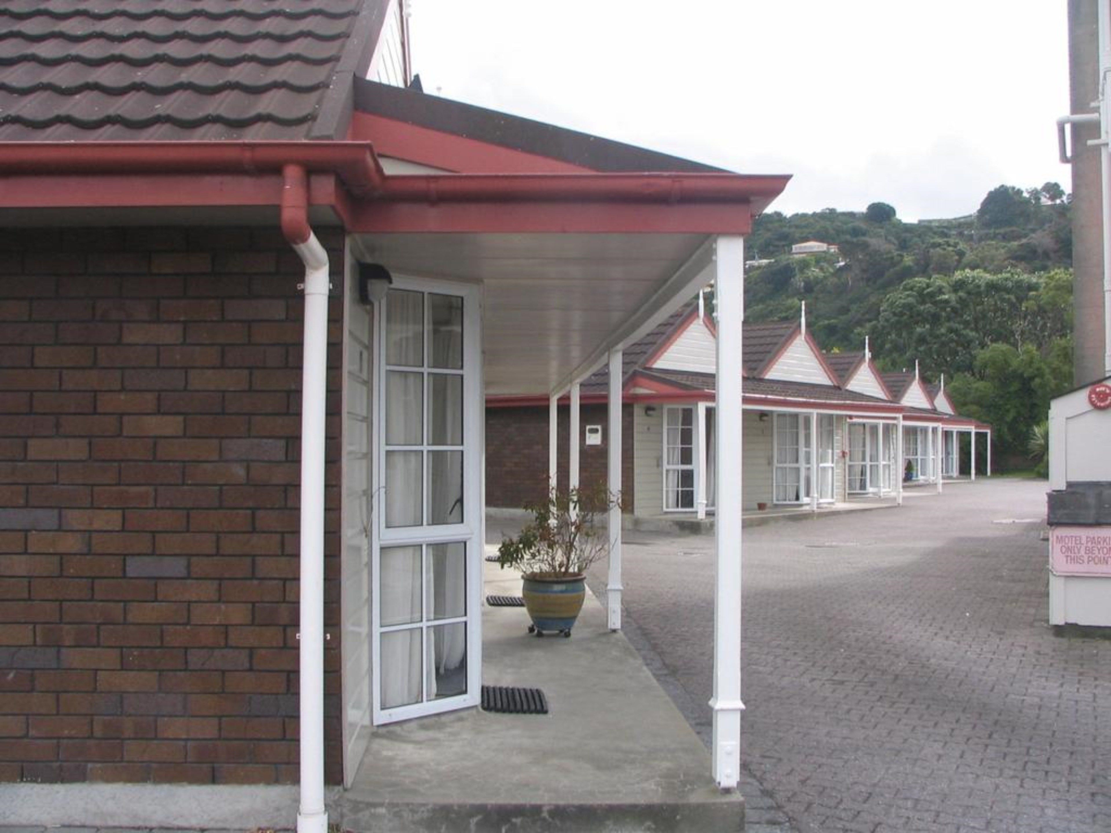 Un motel con fachada de ladrillo y un área de patio cubierta.