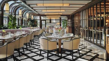 Un restaurante con un interior moderno, que ofrece una variedad de opciones de asientos y un piso con diseño.