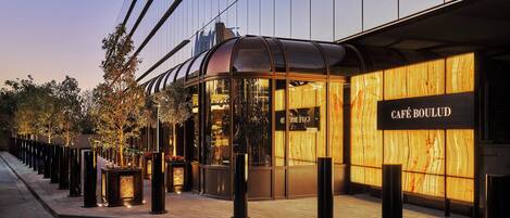 A modern building with a glass facade and a wooden panel design on the right side.