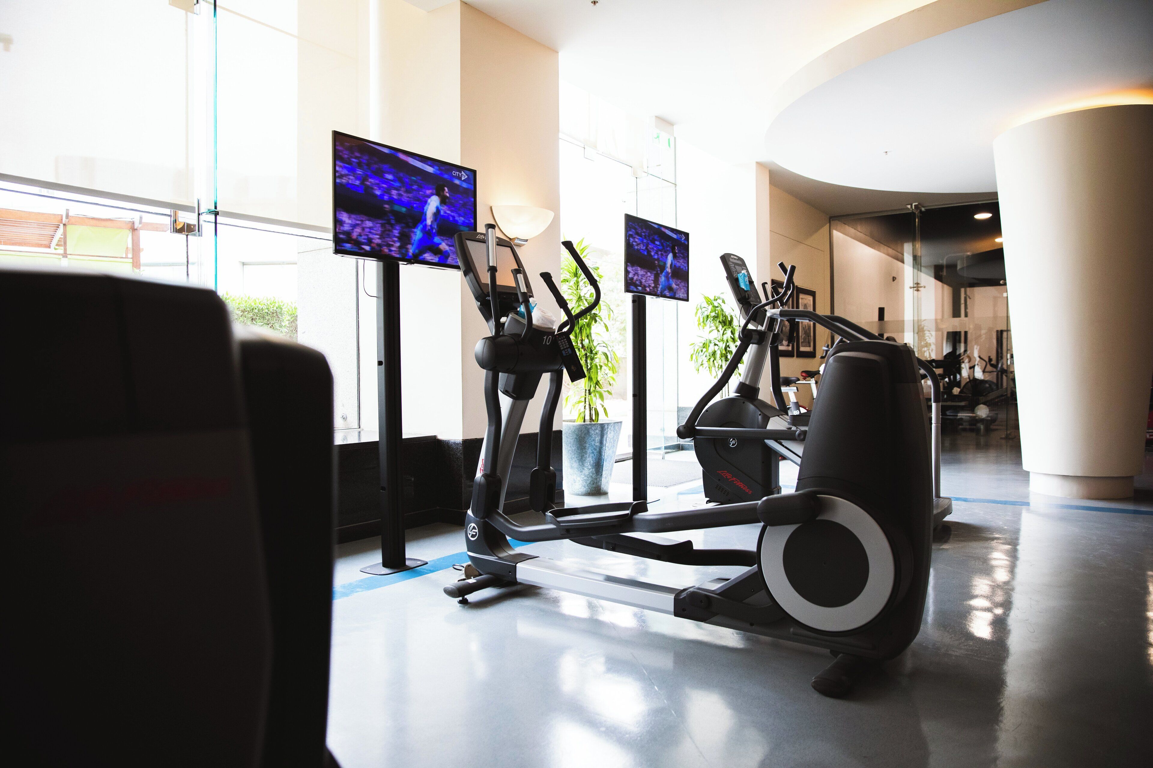 A gym with exercise equipment and large windows.