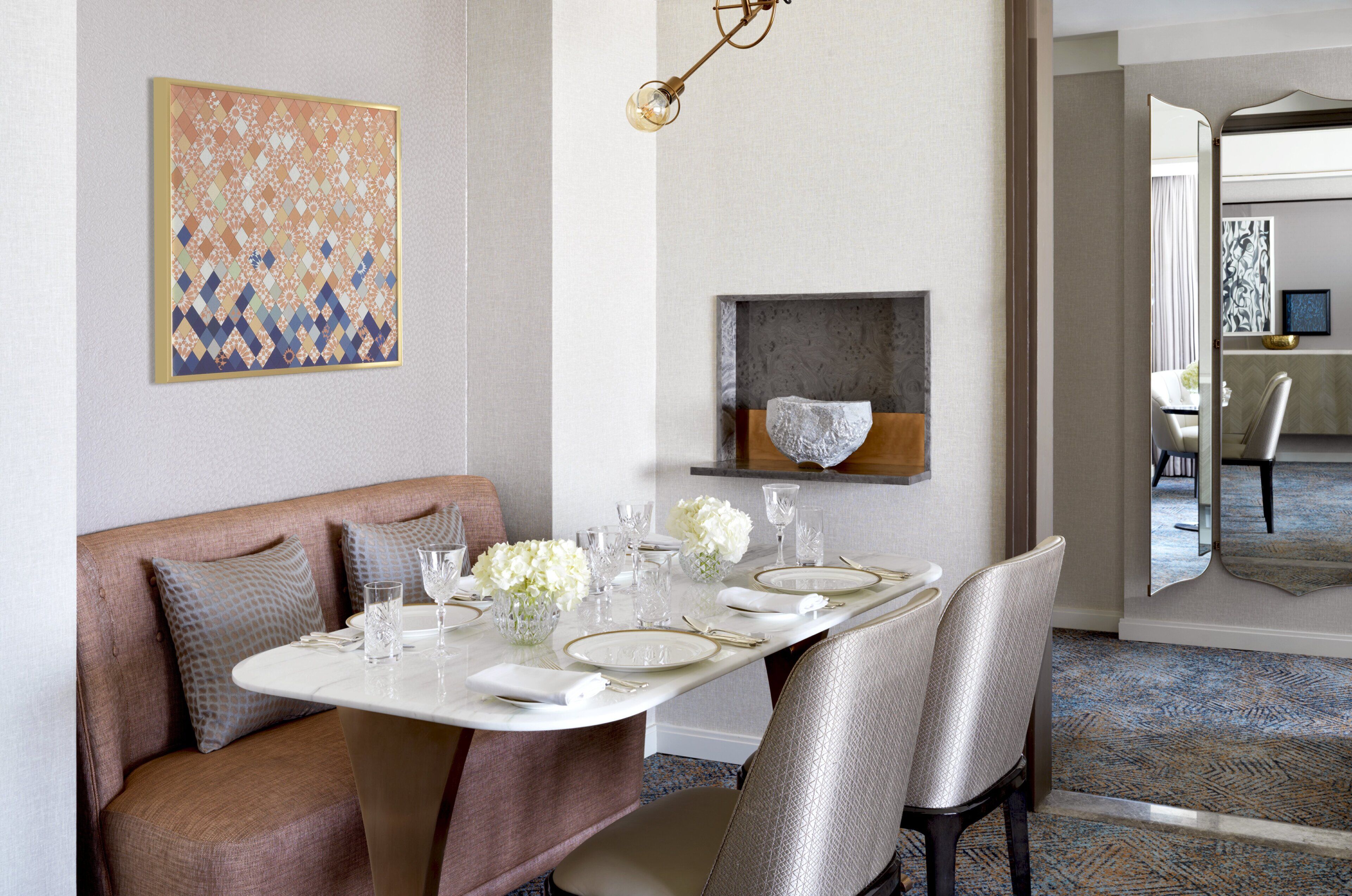 A dining area with a white table set for four, surrounded by cushioned seating.