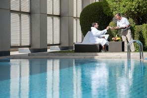 Una piscina al aire libre, tumbonas