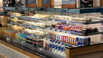 A bakery display case with various baked goods and beverages.