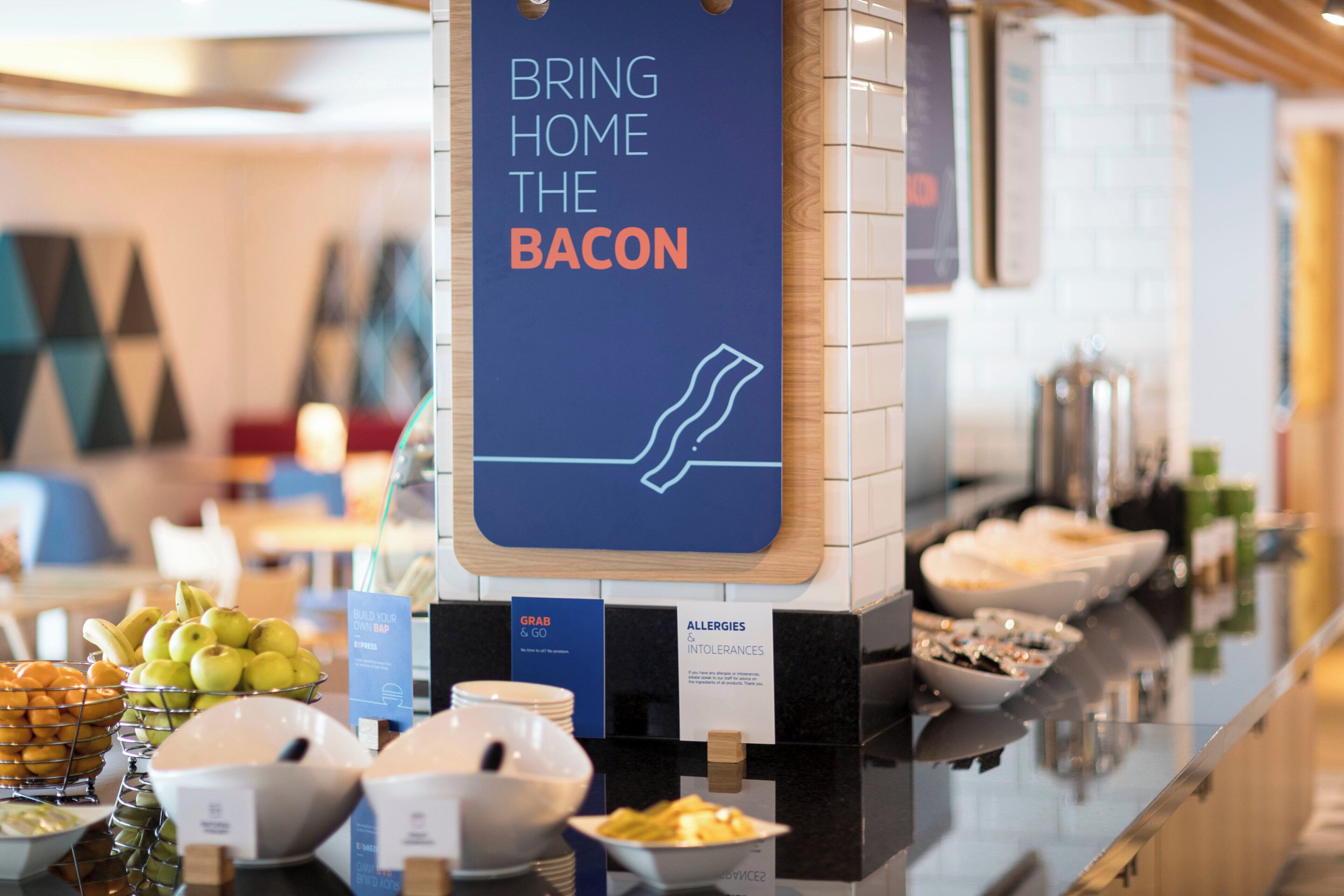 A buffet area with a sign indicating a bacon option.