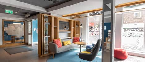 A modern interior with a sofa, chairs, a coffee table, and a large window.