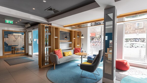 Et moderne interiør med sofa, stole, et sofabord og et stort vindue.