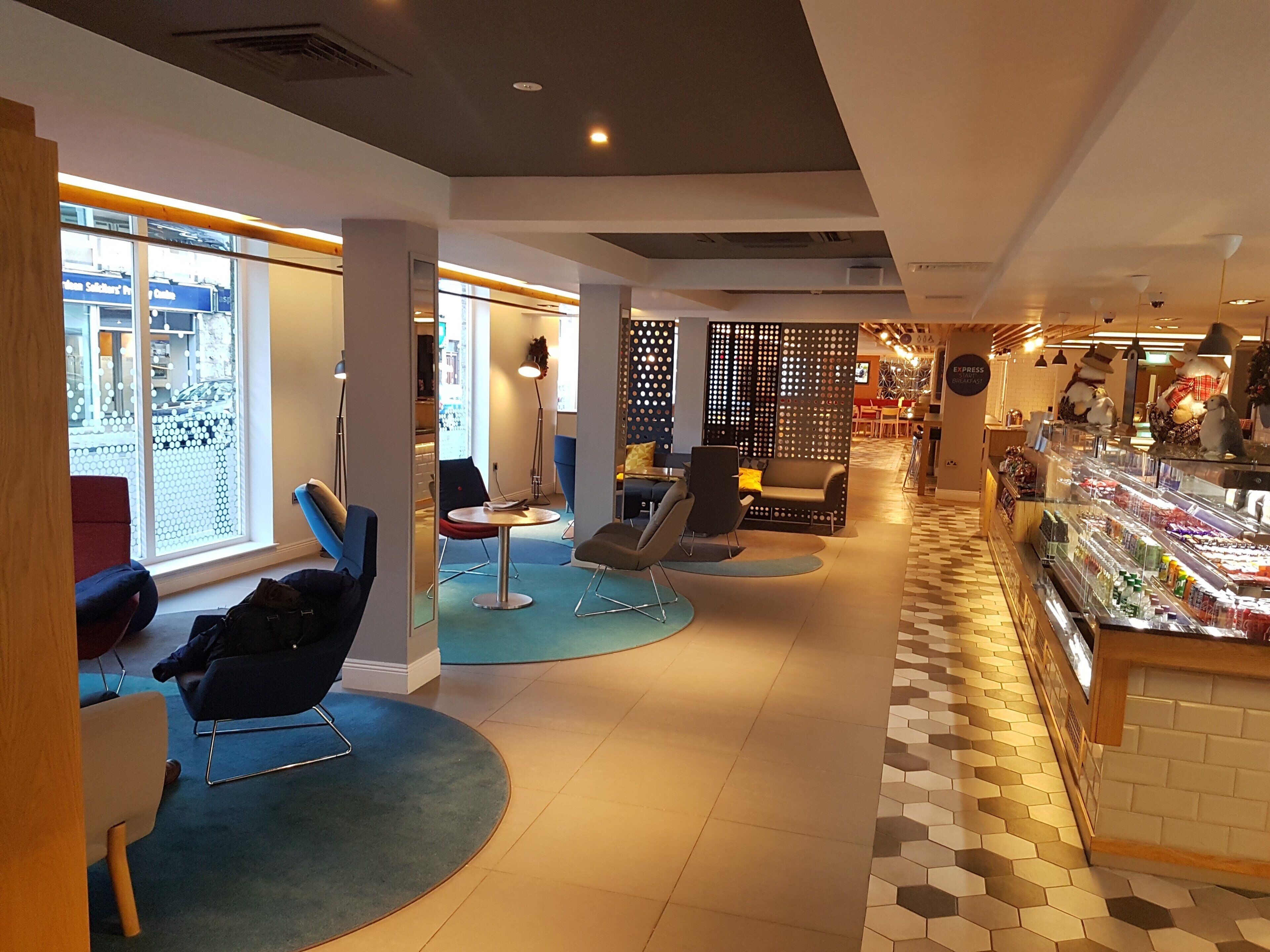 A modern interior with seating areas, a coffee bar, and a view through a window.