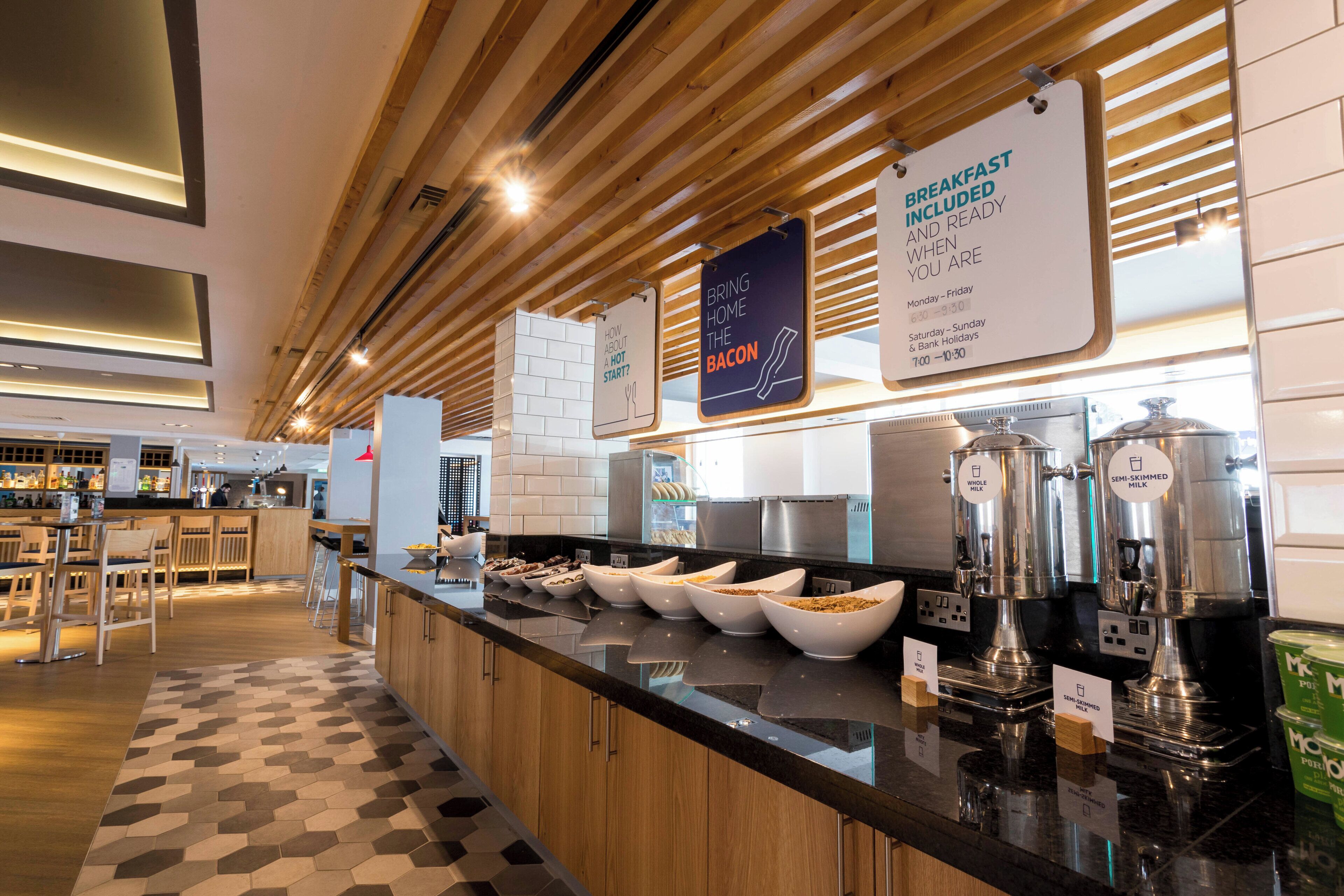 A breakfast bar with various food items and a sign indicating breakfast is included.