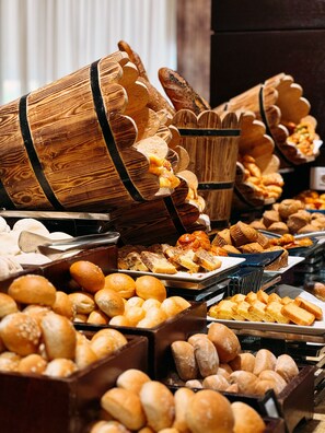 A bakery display with various baked goods in wooden containers.