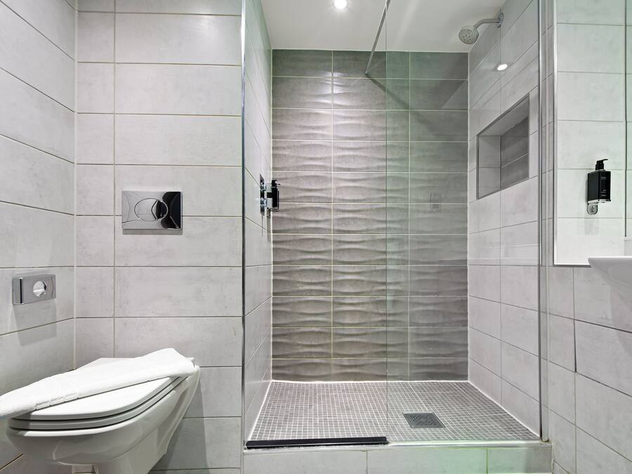 Une salle de bain moderne équipée d’une douche, de toilettes et d’un lavabo.