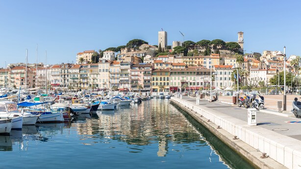 A marina with numerous boats docked, a waterfront promenade, and historic buildings in the background. - Eden Hôtel & Spa Cannes (Cannes)