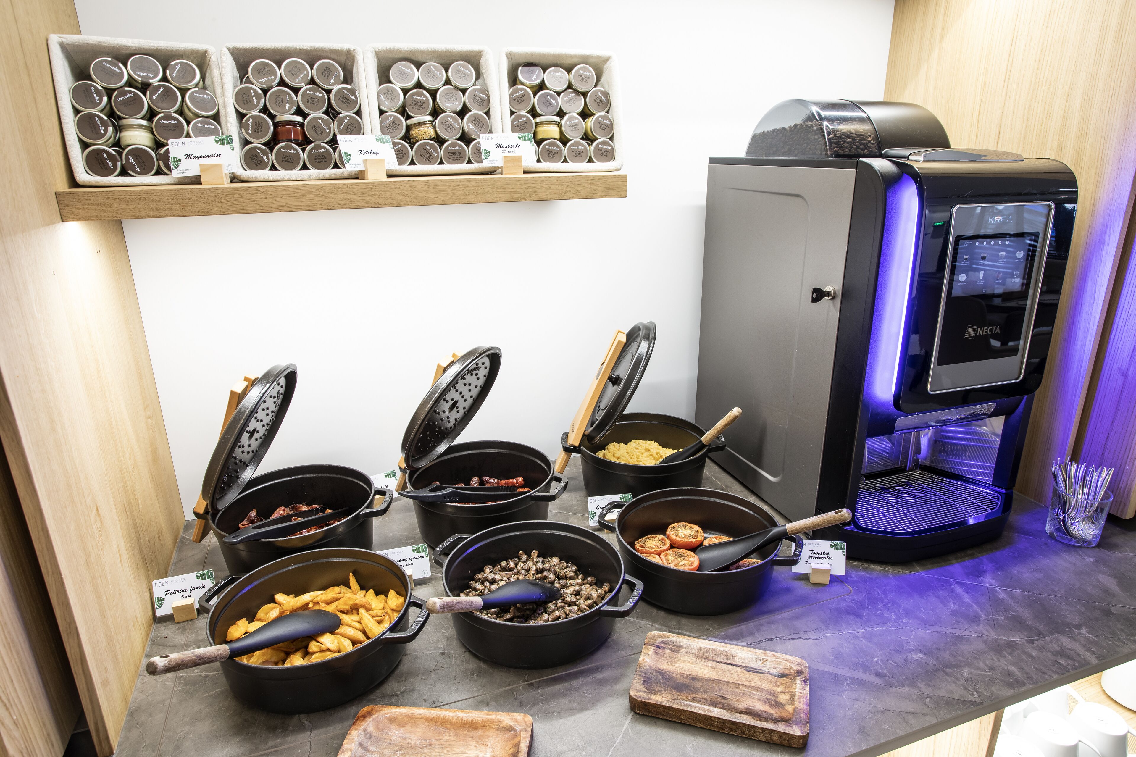 Eine Küchenzeile mit mehreren Kochtöpfen, einer Kaffeemaschine und einem Regal mit Gläsern.