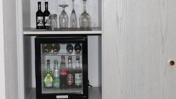 Ein Minikühlschrank mit verschiedenen Flaschen und Gläsern darauf.