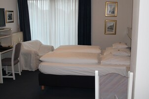 Una habitación de hotel con una cama, un escritorio y una silla.