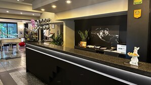 A hotel reception area with a pool table, a piano, and a television displaying a band. - Hotel Comtur (Binasco)