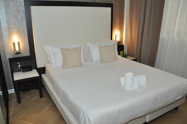 ألحفة محشوة بالريش وميني بار وخزنة داخل الغرفة ومكتب