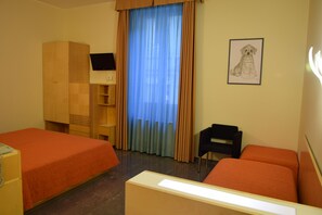 A hotel room with two beds, a desk, a chair, a TV, and a window with curtains. - Hotel Losanna (Milan)