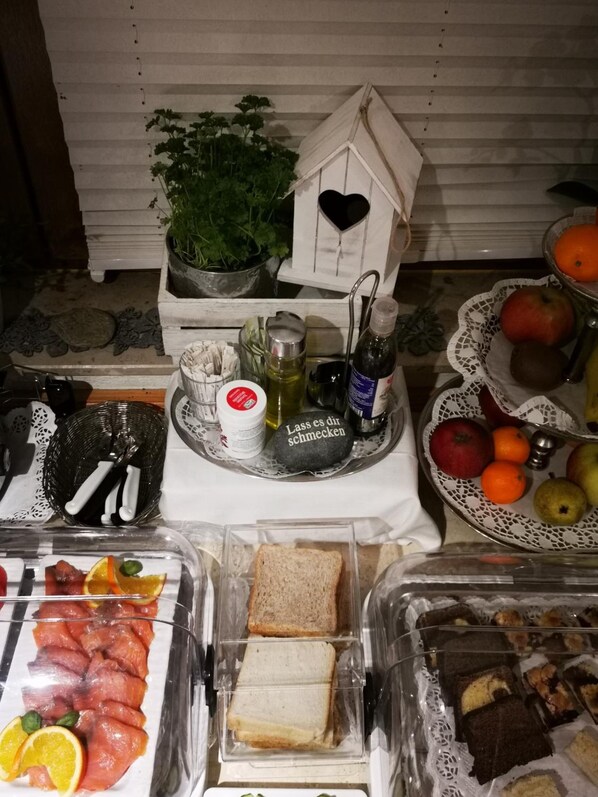 A buffet table with various food items including meats, bread, and desserts. - Airport Hotel Filderpost (Stuttgart)