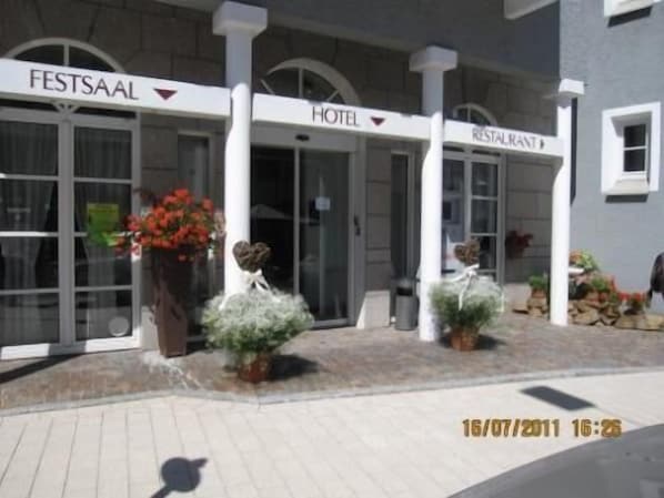 Entrada de un hotel con un cartel que dice "FESTSAAL HOTEL RESTAURANT".