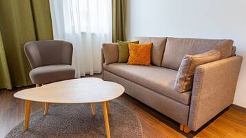 Una sala de estar con un sofá, un sillón y una mesa de centro.