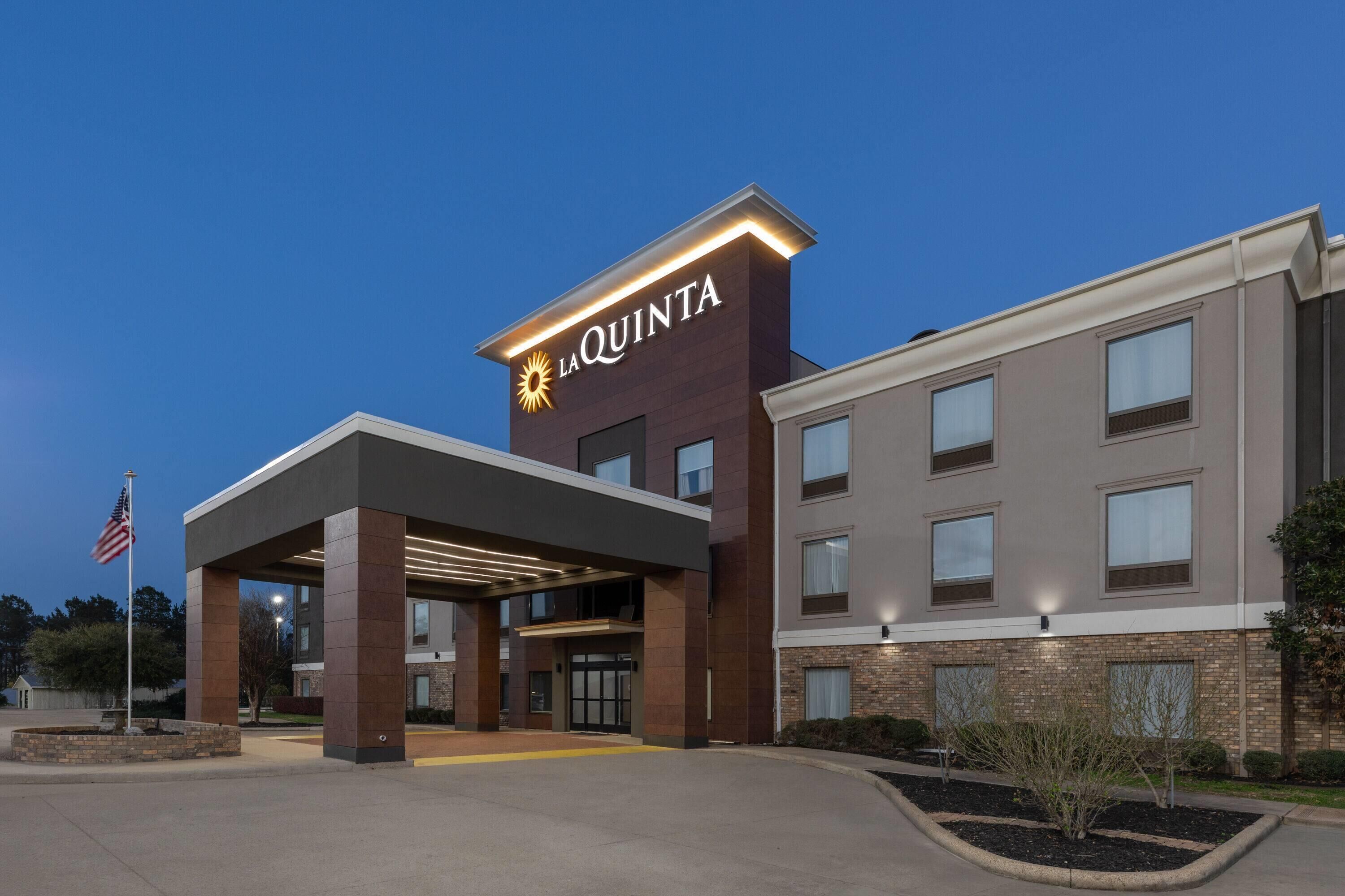 Un hotel de diseño moderno, con un llamativo letrero de 'La Quinta', una entrada cubierta y fachada de ladrillo.
