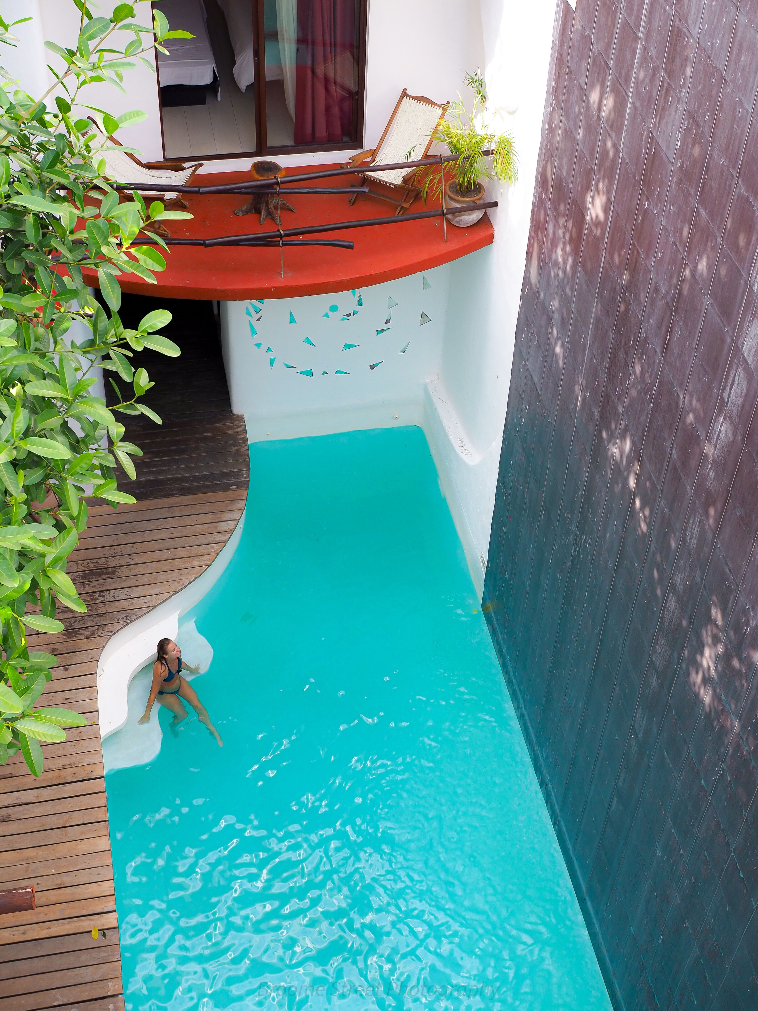 Une petite piscine intérieure, entourée d’une terrasse en bois.