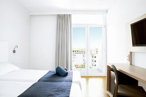 Relax in a serene space with a large bed, flat-screen TV, and a desk for work or relaxation.